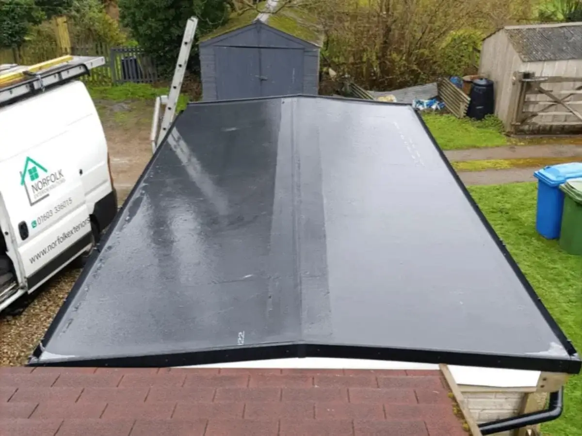 Seamless application of a sleek, weather-resistant dark grey GRP fibreglass flat roof on a domestic garden outbuilding by Norfolk Exterior Solutions